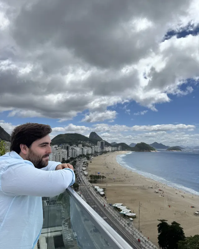 Rafael numa varanda sobre a praia de Copacabana